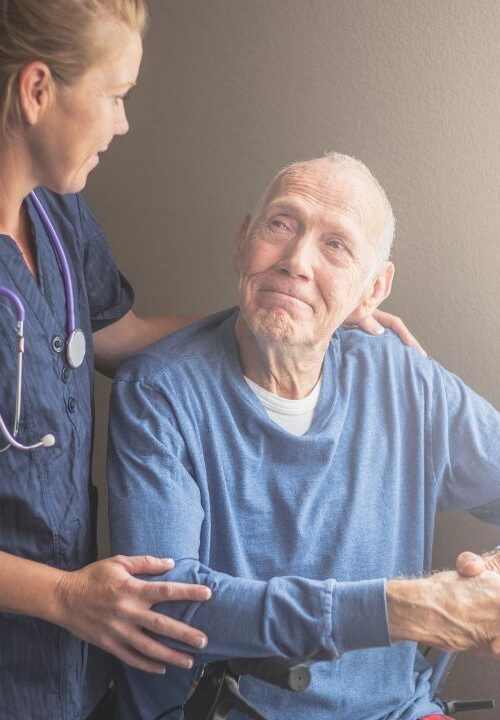 In-home caregiver providing supportive home care to senior man during transitional care period.